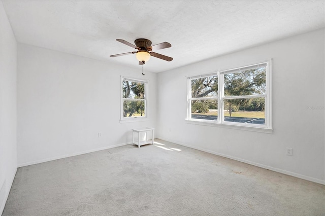 unfurnished room with a ceiling fan, carpet flooring, a textured ceiling, and baseboards