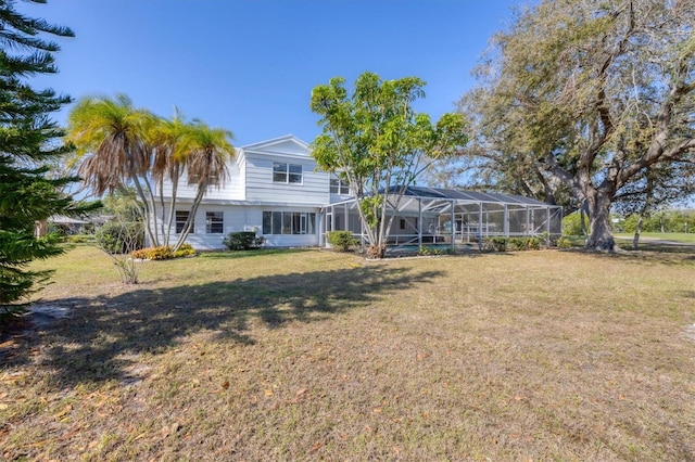 rear view of house featuring a yard and a lanai