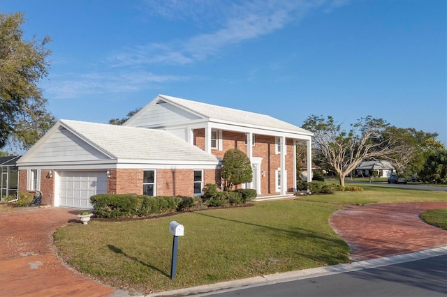 neoclassical home with an attached garage, a front lawn, and brick siding