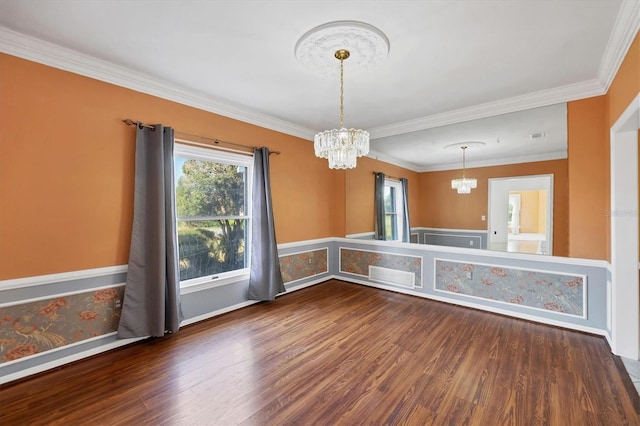 unfurnished dining area with an inviting chandelier, ornamental molding, baseboards, and wood finished floors