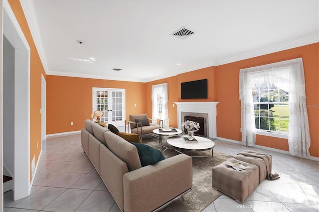 living room with crown molding, baseboards, visible vents, and a fireplace