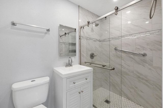 bathroom featuring vanity, a shower stall, and toilet