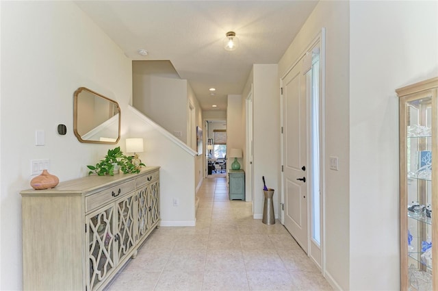 corridor with baseboards and light tile patterned floors