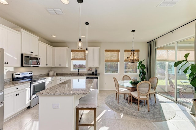 kitchen featuring white cabinetry, visible vents, a kitchen island, and appliances with stainless steel finishes