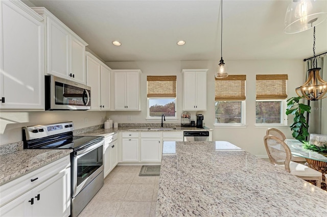 kitchen featuring recessed lighting, stainless steel appliances, a sink, white cabinets, and light stone countertops