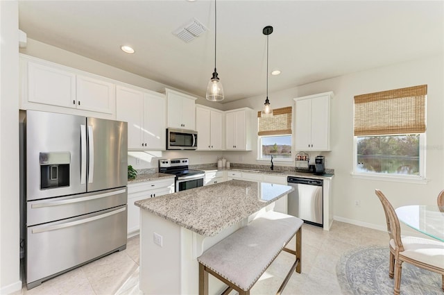 kitchen with visible vents, white cabinets, a center island, stainless steel appliances, and recessed lighting