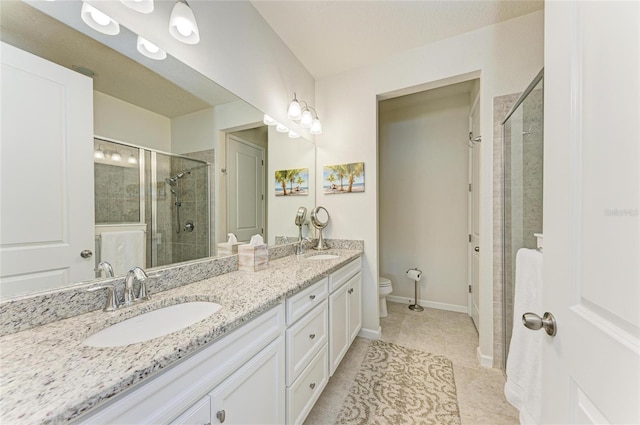 full bathroom featuring double vanity, toilet, a sink, a shower stall, and baseboards