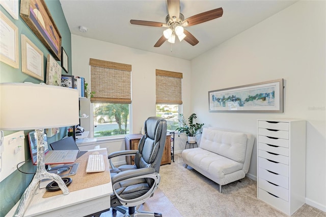 home office with light carpet, baseboards, and a ceiling fan