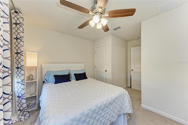 carpeted bedroom featuring ceiling fan, visible vents, and baseboards