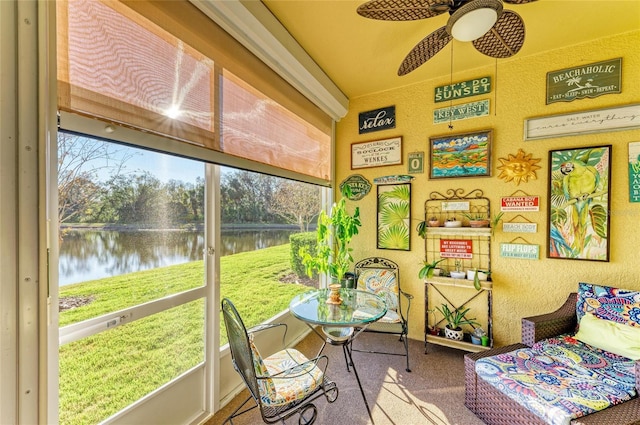 sunroom / solarium featuring a ceiling fan and a water view