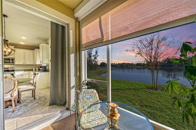 sunroom / solarium featuring a water view