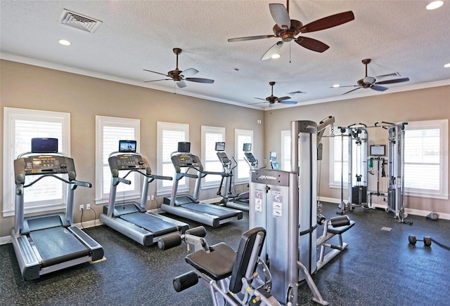 workout area featuring ornamental molding, visible vents, a textured ceiling, and baseboards