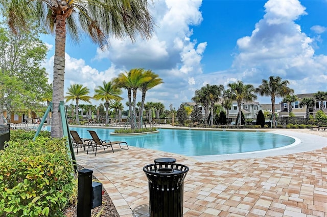 pool with a patio and fence