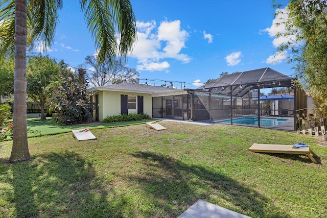 back of house with a yard, an outdoor pool, glass enclosure, and stucco siding