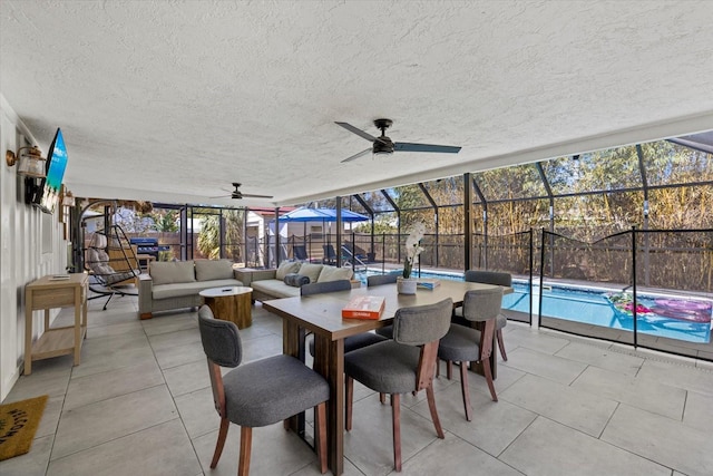 view of patio with a fenced in pool, glass enclosure, ceiling fan, fence, and outdoor lounge area