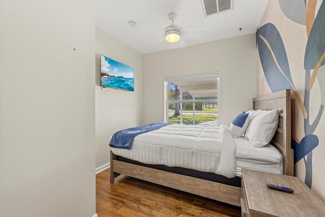 bedroom featuring baseboards, visible vents, and wood finished floors