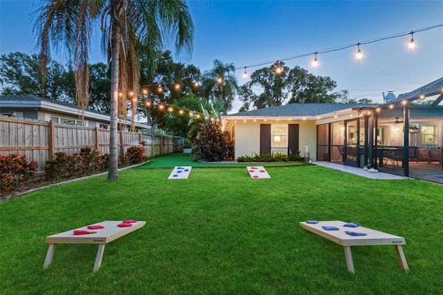 yard at dusk with a patio area and fence