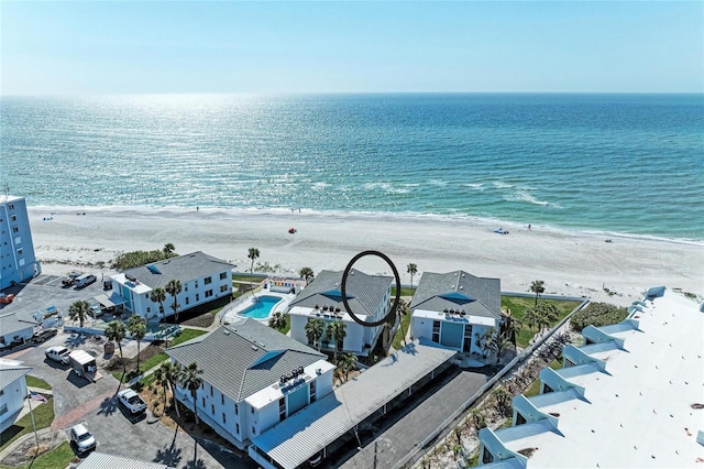 birds eye view of property with a water view and a beach view