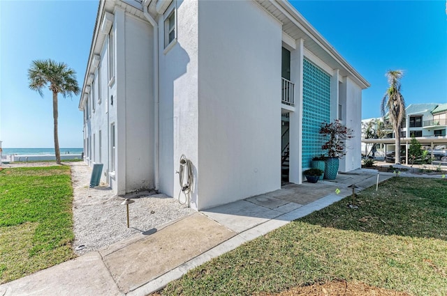 view of side of home featuring a yard and stucco siding