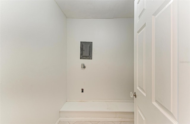 laundry area with laundry area, tile patterned flooring, electric panel, and baseboards