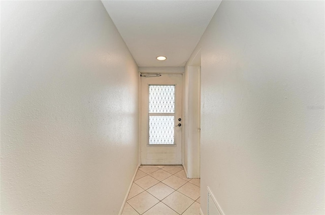 corridor with light tile patterned flooring, visible vents, and baseboards