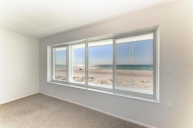 carpeted spare room featuring baseboards