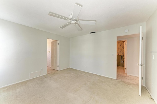 unfurnished room featuring light carpet, ceiling fan, light tile patterned floors, and visible vents