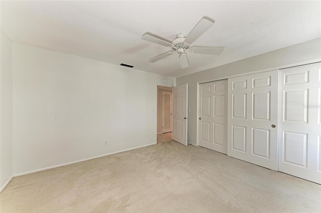 unfurnished bedroom with visible vents, baseboards, light colored carpet, ceiling fan, and a closet