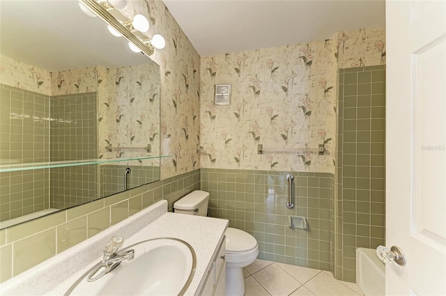 full bathroom featuring a wainscoted wall, tile walls, wallpapered walls, toilet, and tile patterned floors