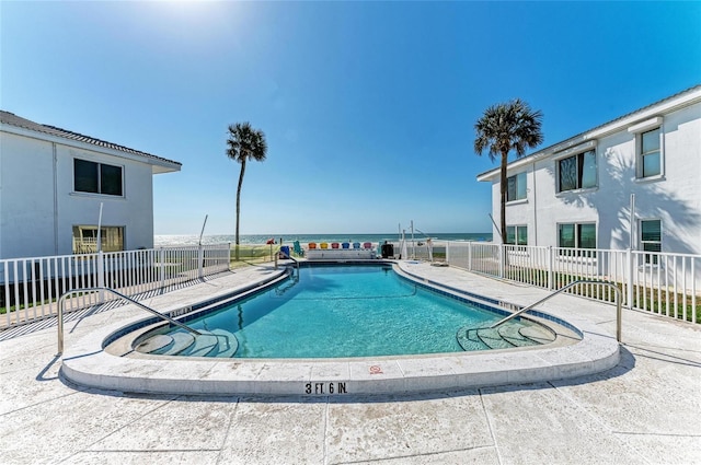 community pool with a patio area and fence