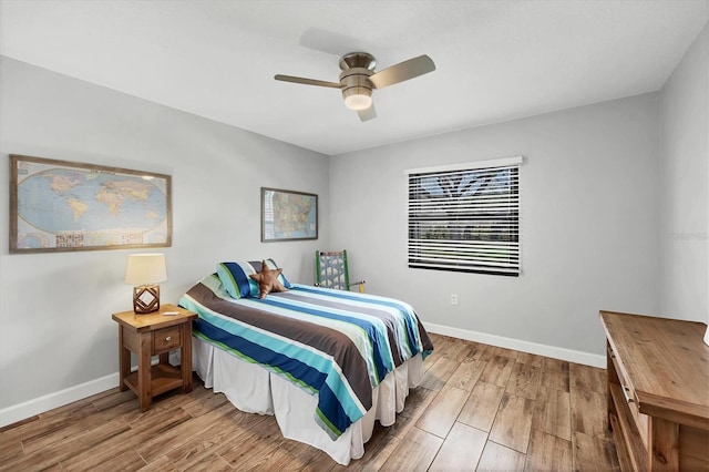 bedroom featuring ceiling fan, baseboards, and wood finished floors