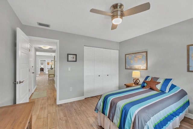 bedroom featuring a ceiling fan, visible vents, baseboards, a closet, and light wood finished floors