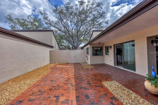 view of patio featuring fence and a gate