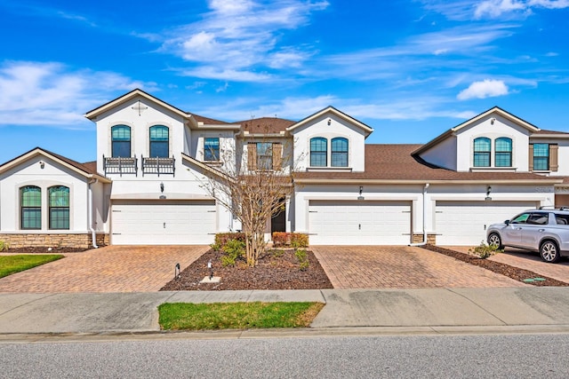 view of front of house featuring a garage, decorative driveway, and stucco siding