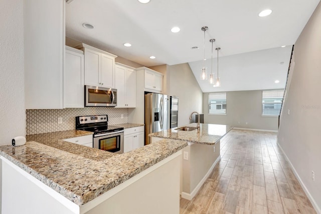 kitchen with backsplash, light wood-style flooring, appliances with stainless steel finishes, white cabinets, and a sink