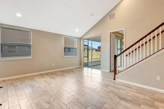 empty room with visible vents, baseboards, light wood-style flooring, stairway, and recessed lighting