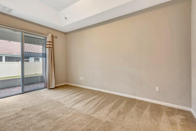 empty room featuring carpet, visible vents, and baseboards