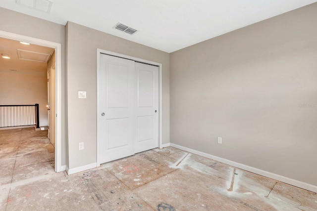 unfurnished bedroom featuring attic access, a closet, visible vents, and baseboards