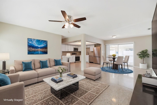 living room featuring light speckled floor, ceiling fan, and visible vents