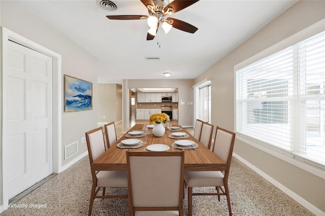 dining area featuring light speckled floor, visible vents, and baseboards