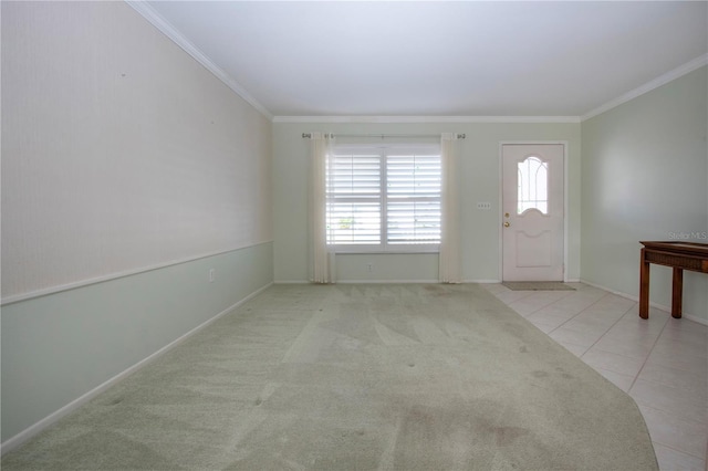 tiled entrance foyer featuring carpet floors, baseboards, and crown molding