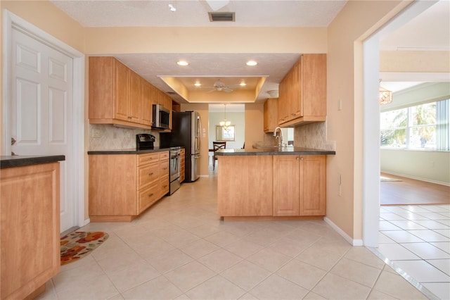 kitchen featuring visible vents, appliances with stainless steel finishes, decorative backsplash, dark countertops, and a raised ceiling