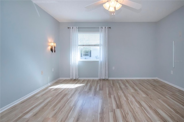 empty room featuring ceiling fan, light wood finished floors, and baseboards