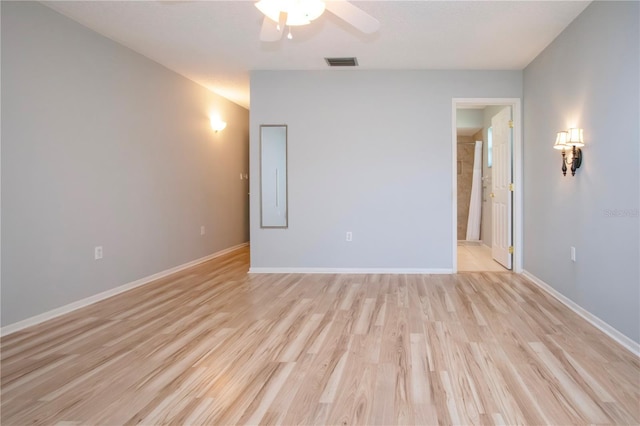 unfurnished room with light wood-style flooring, visible vents, and baseboards