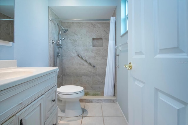 bathroom with tile patterned flooring, a tile shower, vanity, and toilet