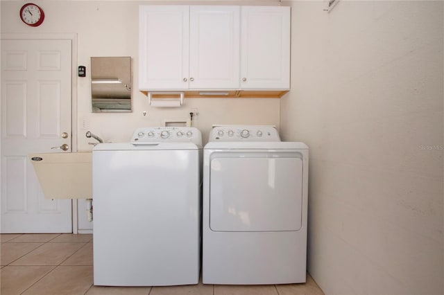 laundry area with cabinet space, independent washer and dryer, and light tile patterned floors