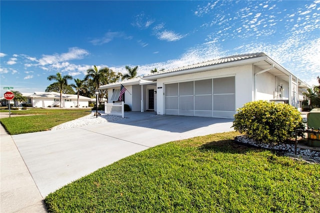 ranch-style home with a front yard, driveway, an attached garage, and stucco siding