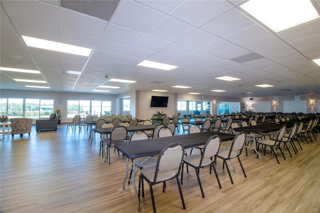 dining area featuring light wood-style floors and a drop ceiling