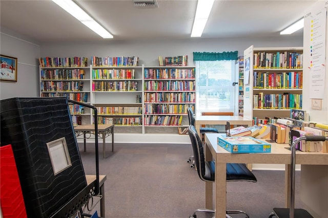 office area with visible vents and wall of books