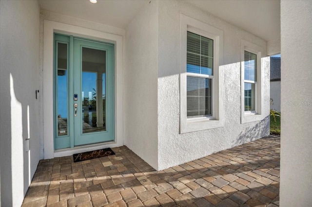 entrance to property featuring stucco siding